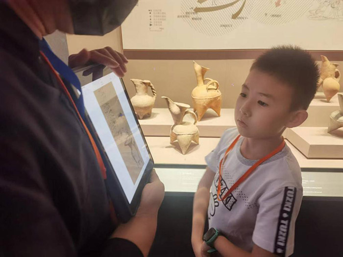 在山东博物馆，前来参观的小朋友正认真听工作人员讲解。记者 杨迪摄